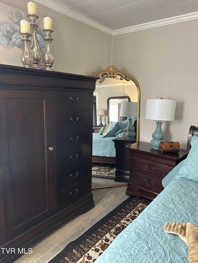 bedroom with crown molding and light hardwood / wood-style floors