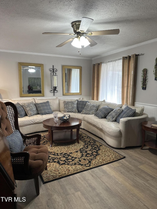 living room with hardwood / wood-style flooring, crown molding, ceiling fan, and a textured ceiling