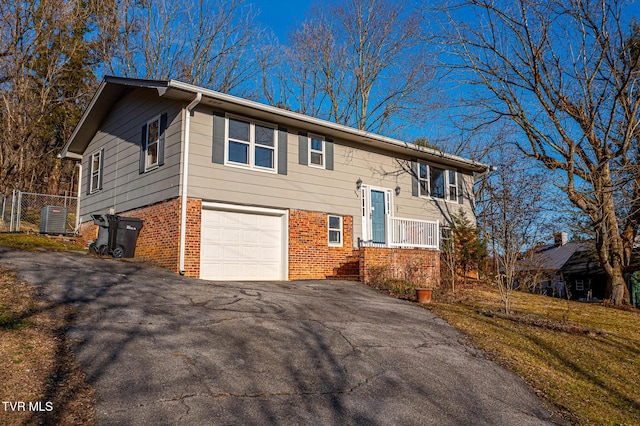 bi-level home with a garage and central AC unit