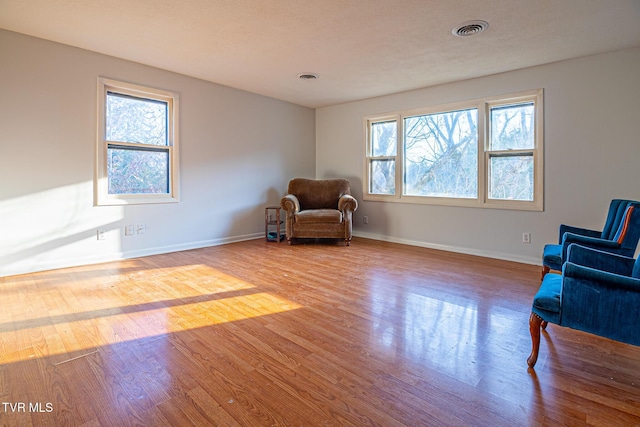 living area with a textured ceiling and light hardwood / wood-style flooring