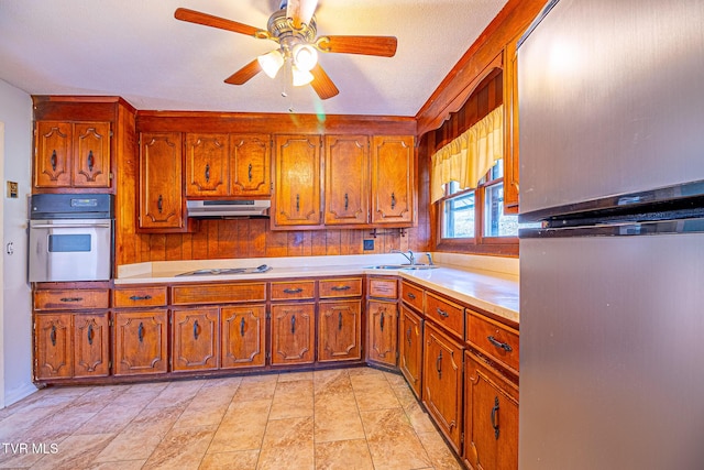 kitchen with sink, gas cooktop, stainless steel oven, and ceiling fan