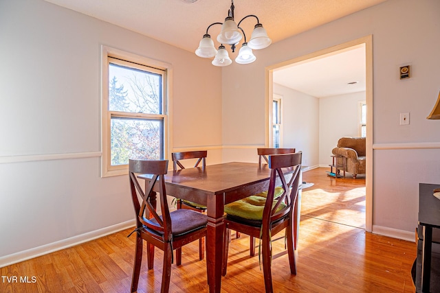 dining space with an inviting chandelier and light hardwood / wood-style floors