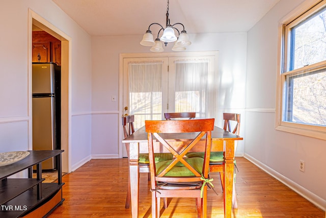 dining area with an inviting chandelier and light hardwood / wood-style flooring