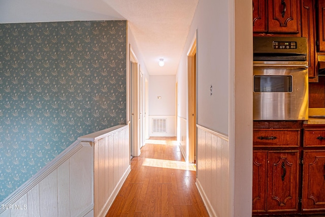 corridor with light hardwood / wood-style floors