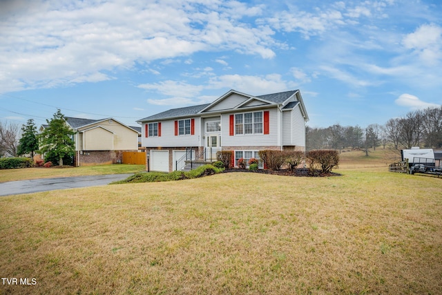 raised ranch with a garage and a front lawn