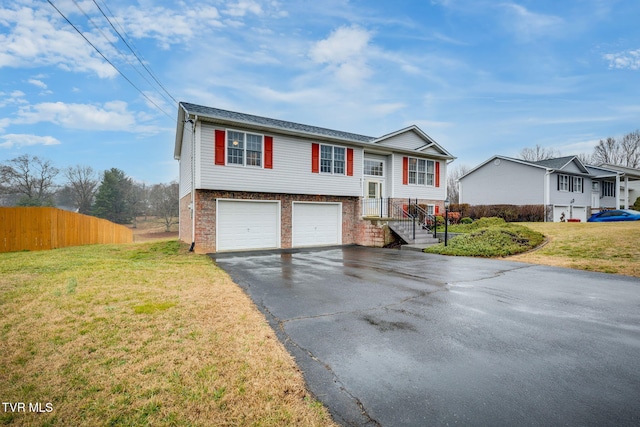 raised ranch with a garage and a front yard