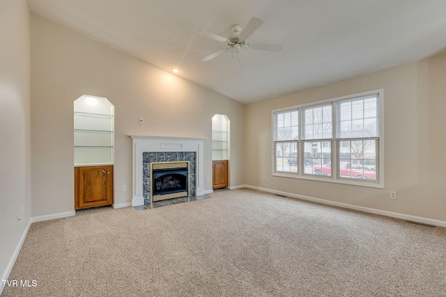 unfurnished living room with ceiling fan, lofted ceiling, light carpet, and a high end fireplace