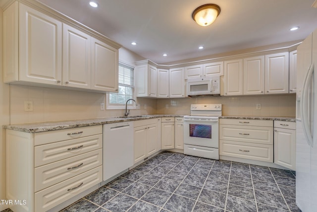 kitchen featuring sink, white cabinetry, light stone counters, white appliances, and decorative backsplash