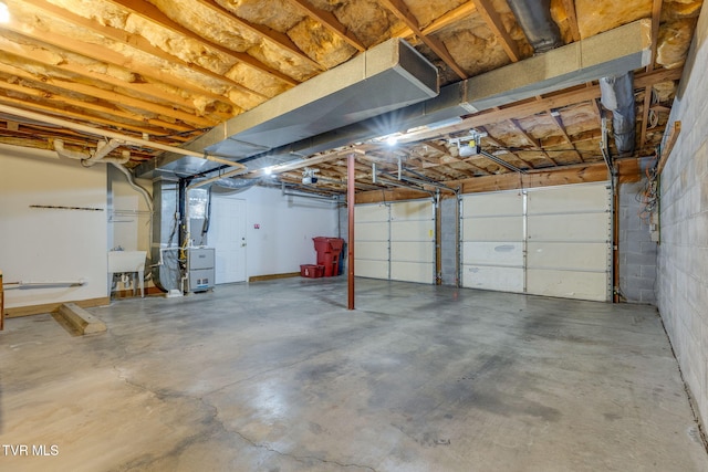 garage featuring heating unit, sink, and a garage door opener