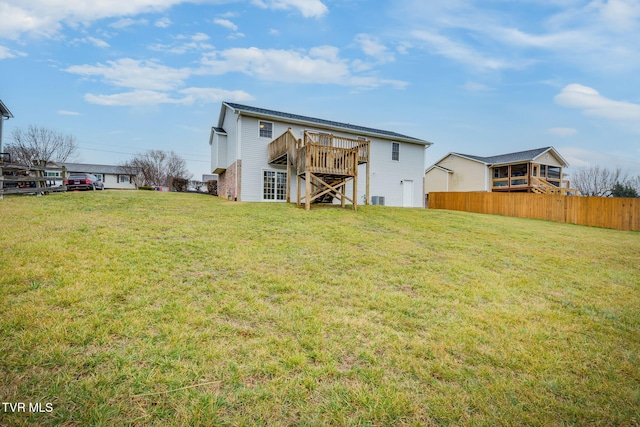 rear view of property featuring a wooden deck, a yard, and cooling unit