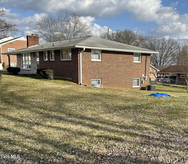 back of house with a yard and central air condition unit