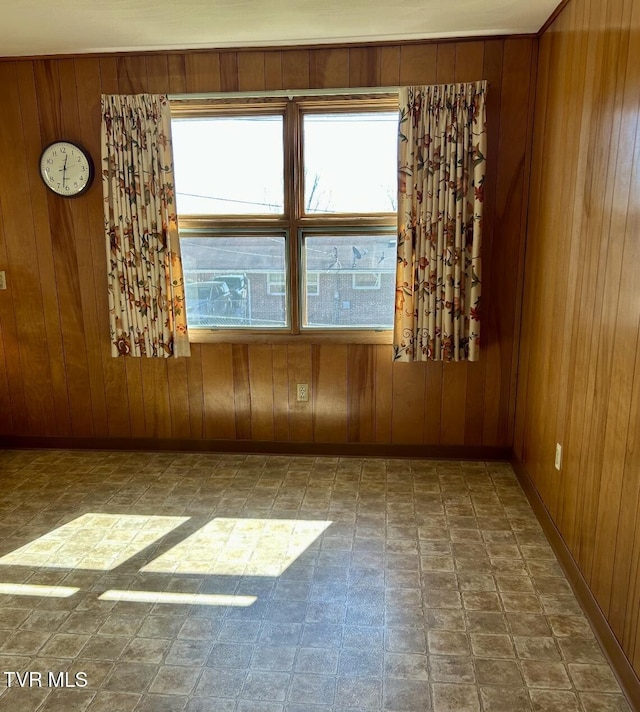 spare room featuring wooden walls