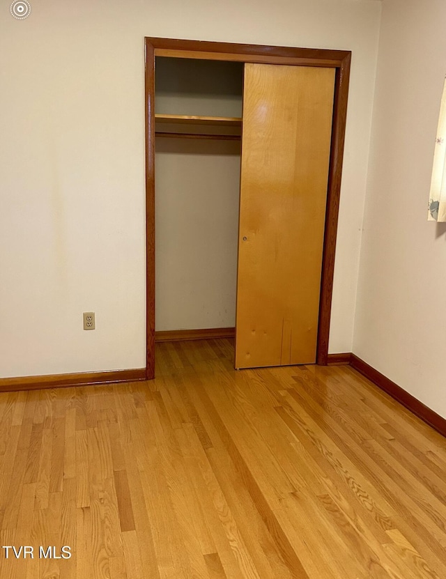 unfurnished bedroom featuring light hardwood / wood-style floors and a closet