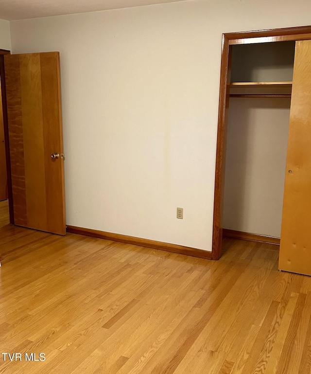 unfurnished bedroom featuring light wood-type flooring and a closet