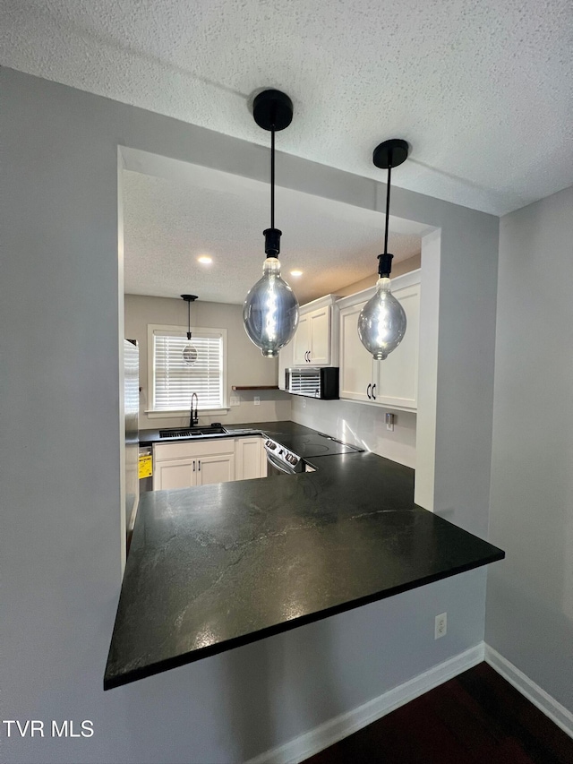 kitchen featuring sink, white cabinetry, decorative light fixtures, a textured ceiling, and electric stove