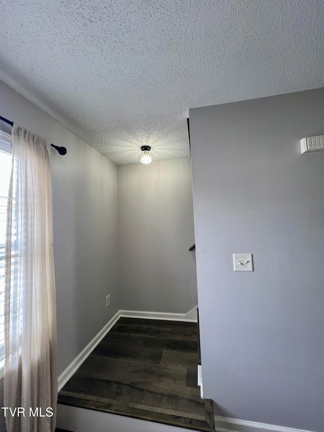 stairway with hardwood / wood-style floors and a textured ceiling