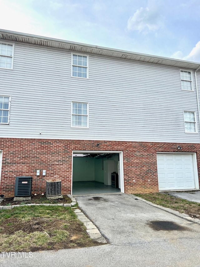 view of property exterior featuring a garage and central air condition unit