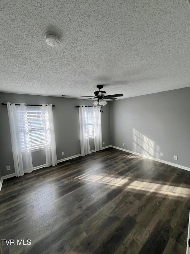 spare room featuring ceiling fan, dark hardwood / wood-style floors, and a textured ceiling