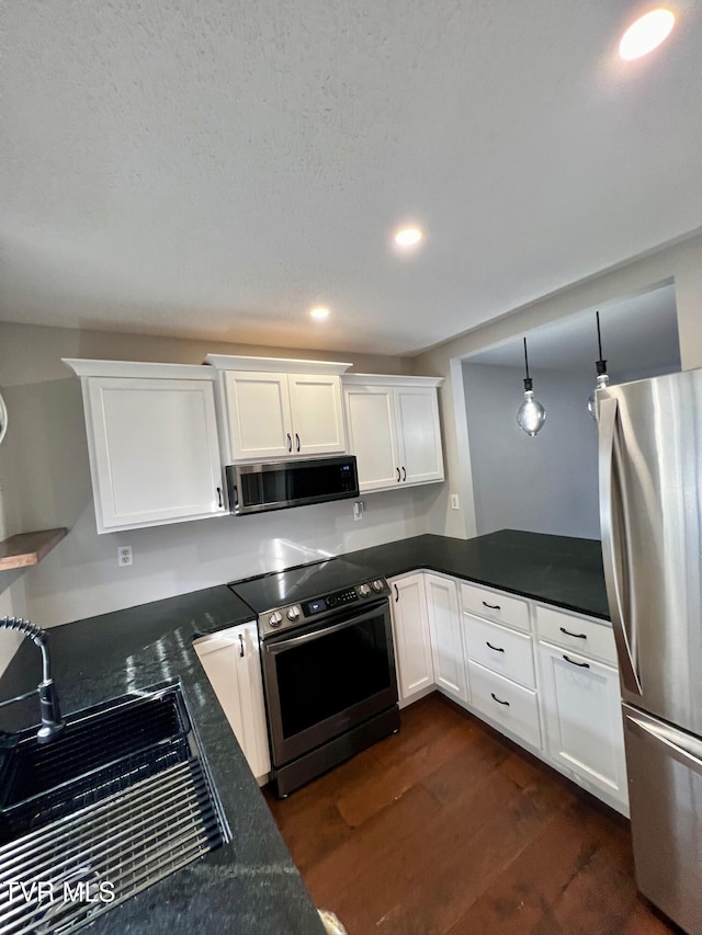 kitchen with pendant lighting, sink, white cabinets, dark hardwood / wood-style flooring, and stainless steel appliances