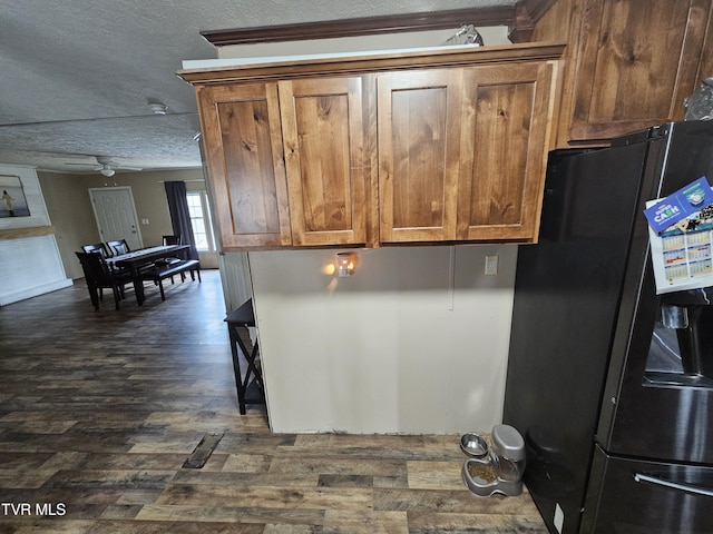 kitchen featuring ceiling fan, black refrigerator with ice dispenser, dark hardwood / wood-style floors, and a textured ceiling