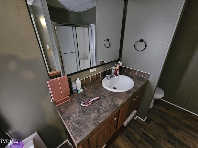 bathroom featuring wood-type flooring, toilet, and vanity