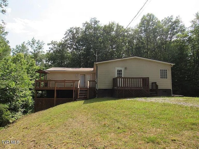 rear view of house with a yard and a deck