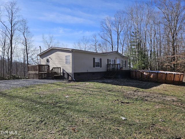 view of side of home with a pool side deck and a lawn