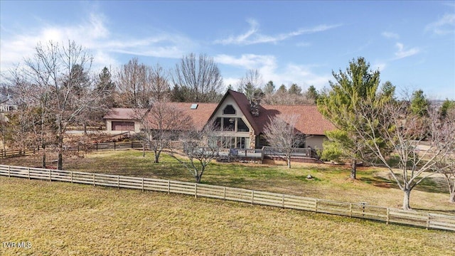 rear view of property with a rural view and a lawn