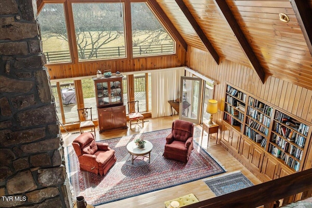 living room featuring wood ceiling, wooden walls, lofted ceiling with beams, and light hardwood / wood-style floors