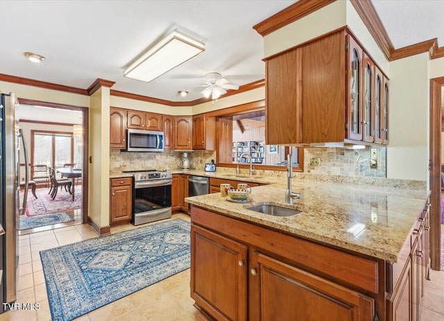 kitchen featuring light stone counters, appliances with stainless steel finishes, sink, and tasteful backsplash