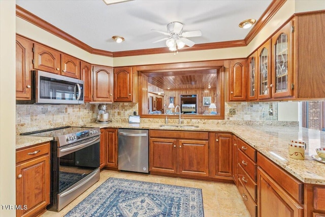 kitchen featuring light stone counters, appliances with stainless steel finishes, sink, and tasteful backsplash