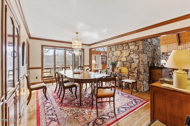 dining space featuring ornamental molding, a chandelier, and light hardwood / wood-style floors