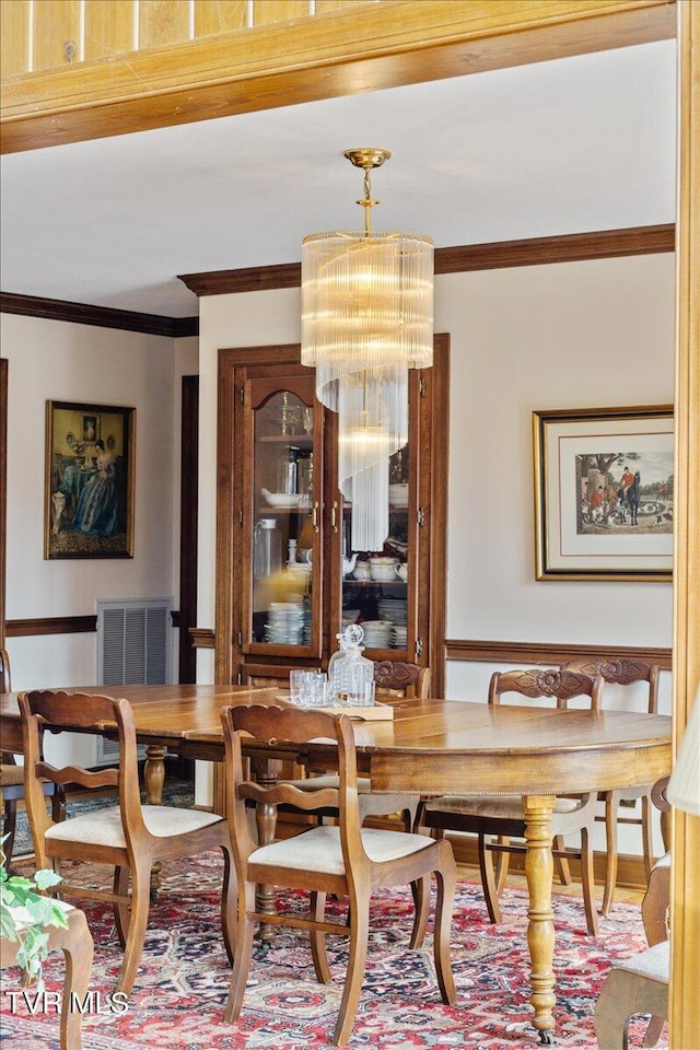 dining area featuring ornamental molding and a chandelier