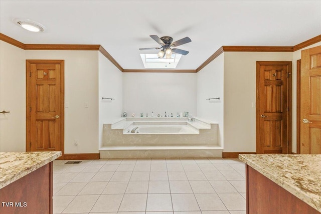 bathroom featuring crown molding, tile patterned flooring, a skylight, vanity, and a tub