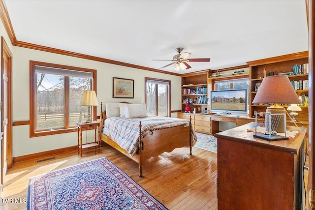 bedroom featuring crown molding, multiple windows, and light wood-type flooring