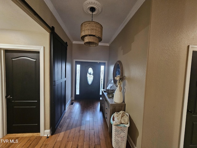 entryway with crown molding, a barn door, and dark hardwood / wood-style floors