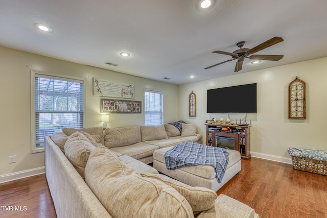 living room featuring dark wood-type flooring and ceiling fan