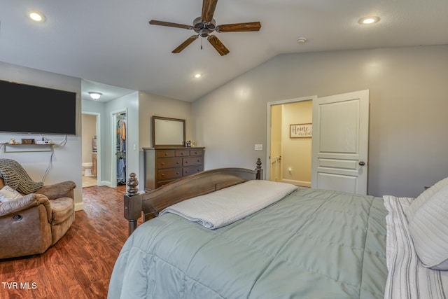 bedroom featuring connected bathroom, wood-type flooring, a spacious closet, vaulted ceiling, and ceiling fan