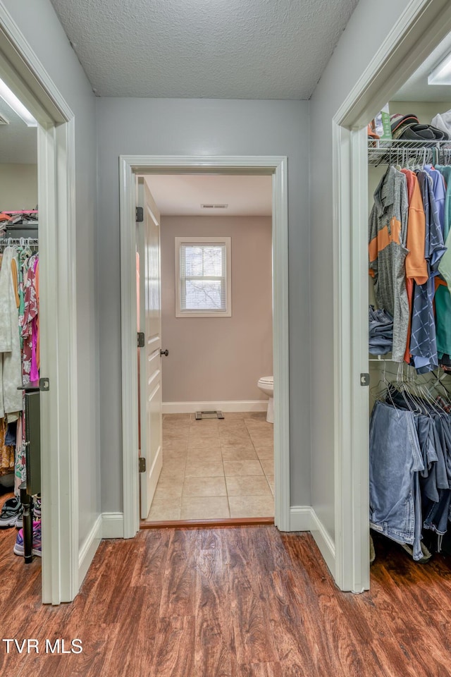 hall with light tile patterned floors and a textured ceiling