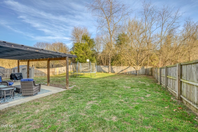 view of yard with a trampoline, a storage unit, and a patio