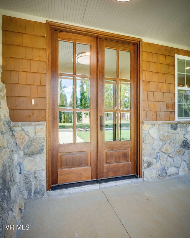 entrance to property featuring stone siding and french doors