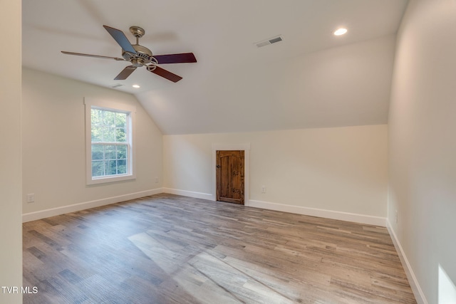 additional living space featuring lofted ceiling, light wood finished floors, baseboards, and visible vents