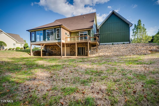 rear view of house featuring stone siding, a deck, board and batten siding, and a yard