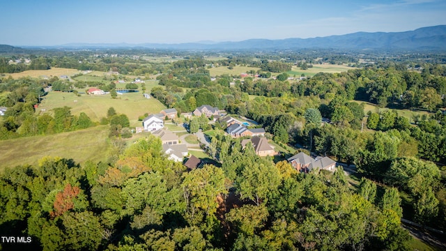 drone / aerial view featuring a residential view, a mountain view, and a view of trees