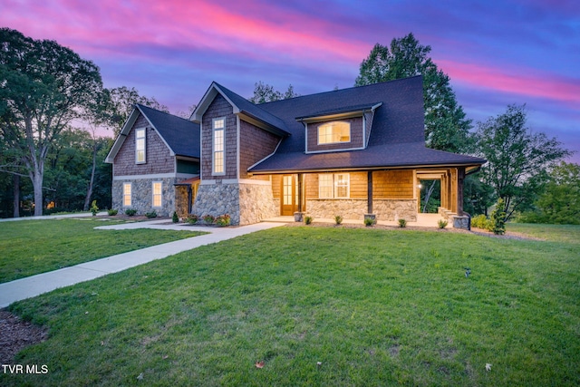 view of front of property featuring stone siding and a lawn