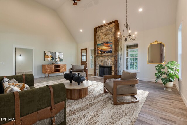 living area featuring a fireplace, recessed lighting, light wood-style flooring, high vaulted ceiling, and baseboards