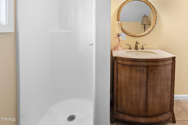 bathroom with walk in shower, vanity, and tile patterned flooring