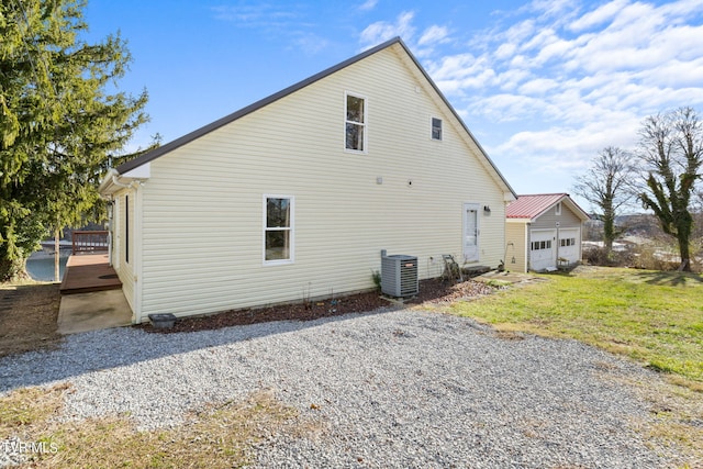 view of home's exterior featuring central AC, a yard, and a garage