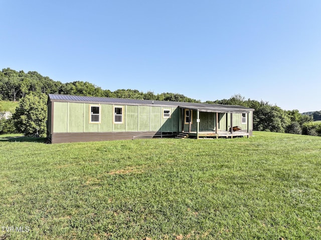 view of front of property featuring metal roof and a front lawn