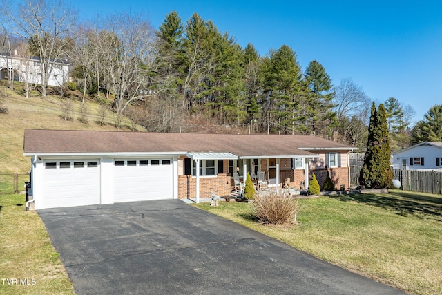 ranch-style home with aphalt driveway, covered porch, fence, a garage, and a front lawn